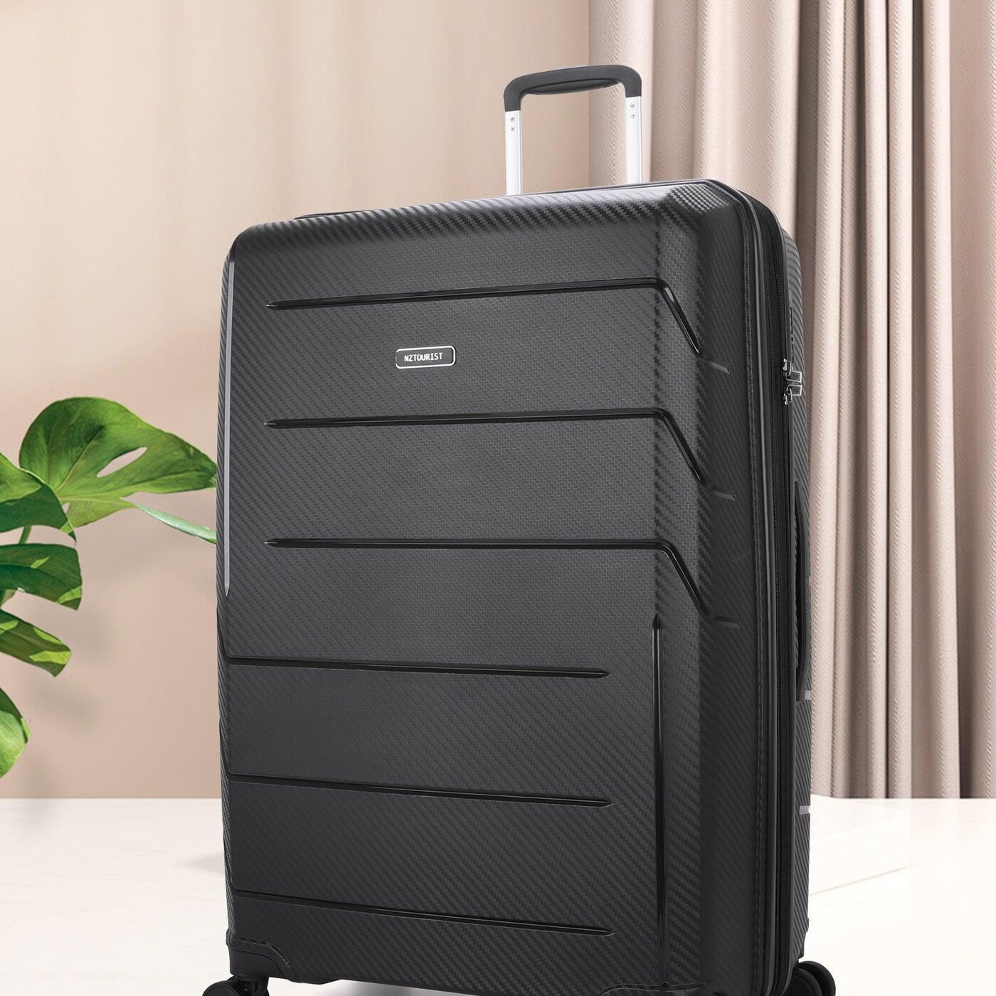 Black San Michelle hard shell suitcase standing upright in a warm lit interior
